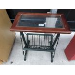 A METALWARE MAGAZINE RACK/TABLE WITH GLASS TOP