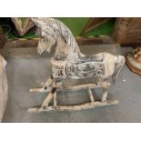 AN ORNAMENTAL WOODEN ROCKING HORSE WITH CARVED DETAIL