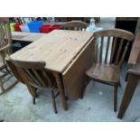 A PINE DROP-LEAF KITCHEN TABLE AND THREE CHAIRS