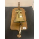 A BRASS SHIPS BELL MOUNTED ON A WOODEN PLINTH TO INCLUDE AN ENGRAVED DATE PLAQUE