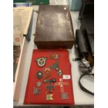 A SMALL VINTAGE LEATHER SUITCASE AND AN ASSORTMENT OF WAR MEDALS AND FABRIC MILITARY PATCHES