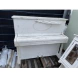 A WHITE PAINTED UPRIGHT PIANO