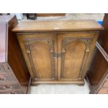 A LIGHT OAK OLD ABBEY STYLE TWO DOOR CD CABINET, 31" WIDE