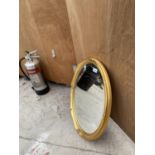 A DECORATIVE OVAL GILT FRAMED BEVEL EDGED MIRROR