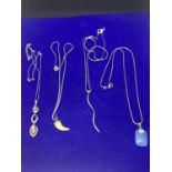 FOUR SILVER NECKLACES MARKED 925 WITH PENDANTS TO INCLUDE A BLUE STONE, TOOTH, CLEAR STONE DROP