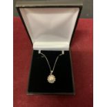 A SILVER CHAIN MARKED 925 WITH A PEARLISED AND CLEAR STONE PENDANT IN A PRESENTATION BOX