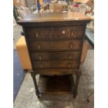 AN OAK MUSIC CABINET WITH FOUR FALL FRONT DRAWERS AND LOWER SHELF ON BARLEY TWIST SUPPORTS