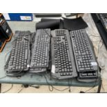 A QUANTITY OF COMPUTER KEYBOARDS AND MOUSE MATS