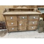 A VINTAGE WOODEN KITCHEN DRESSER BASE ENCLOSING SEVEN DRAWERS AND ONE CUPBOARD