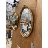 A DECORATIVE OVAL GILT FRAMED MIRROR