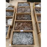 FIVE WOODEN STORAGE BOXES CONTAINING A LARGE QUANTITY OF NAILS