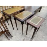 A NEST OF THREE MAHOGANY TABLES WITH INSET LEATHER TOPS