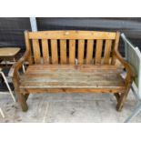 A SOLID WOODEN SLATTED GARDEN BENCH