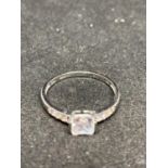 A 9 CARAT WHITE GOLD RING WITH CLEAR CENTRE STONE AND ON SHOULDERS SIZE 0
