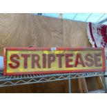 AN ILLUMINATED 'STRIPTEASE' SIGN