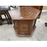 A MID 20TH CENTURY HEXAGONAL DRINKS TABLE WITH TWO CARVED PANELD OORS, 25x22"