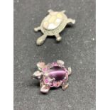 TWO SILVER TURTLE BROOCHES ONE WITH A SHELL DESIGN AND ONE WITH A PURPLE STONE