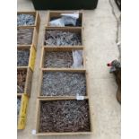 FIVE WOODEN STORAGE BOXES CONTAINING A LARGE QUANTITY OF NAILS