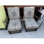 A PAIR OF ERCOL FIRESIDE CHAIRS WITH FITTED CUSHIIONS AND ARCHED BACK DECORATION