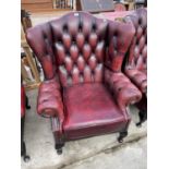 AN OXBLOOD WINGED CHAIR ON CABRIOLE LEGS