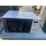 A SILVER MORRISONS MICROWAVE OVEN BELIEVED IN WORKING ORDER BUT NO WARRANTY