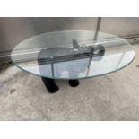 AN OVAL GLASS TOPPED COFFEE TABLE WITH FIGURAL ELEPHANT BASE - 45" X 32"