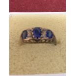 A 9 CARAT YELLOW GOLD RING WITH THREE IN LINE BLUE STONES GROSS WEIGHT APPROXIMATELY 2.1 GRAMS