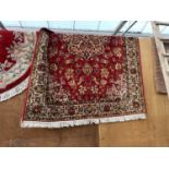 A LARGE RED PATTERNED RUG