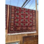 A LARGE RECTANGULAR RED PATTERNED RUG