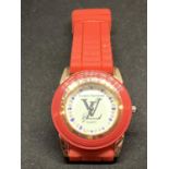 A FASHION WATCH WITH A RED STRAP