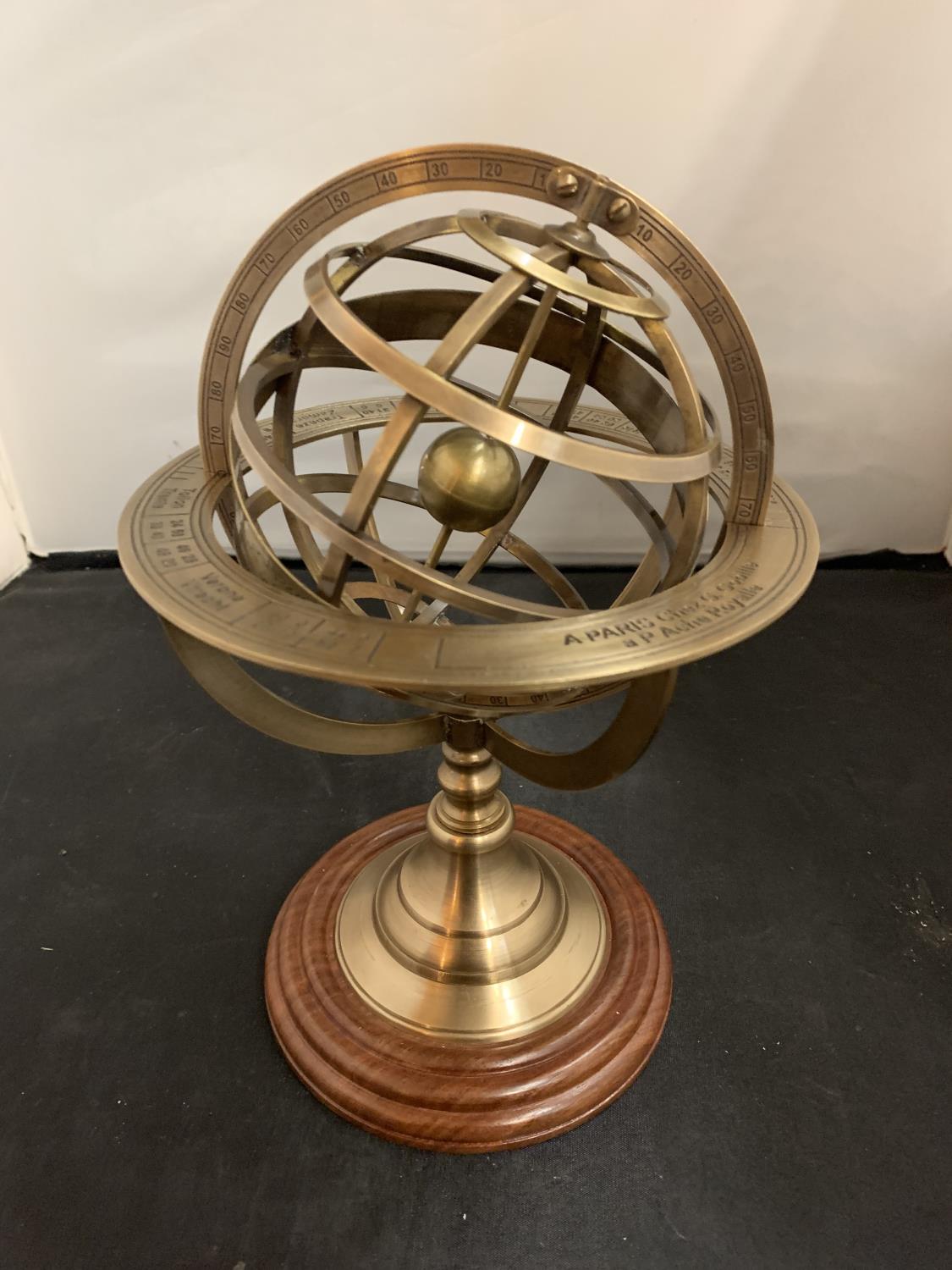 A BRASS ARMILLARY SHPERE ON A WOODEN BASE