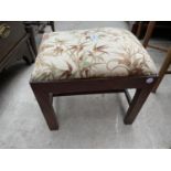 A SMALL STOOL WITH UPHOLSTERED TOP