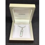 A SILVER NECKLACE AND A DROP BAR PENDANT WITH A GREEN STONE FLOWER DESIGN IN A PRESENTATION BOX