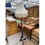AN EARLY 20TH CENTURY OAK STANDARD LAMP COMPLETE WITH SHADE