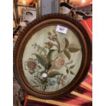 A ORNATE OVAL FRAMED EMBROIDERED 'FLOWERS' PICTURE