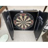 A WINMAU DART BOARD IN WOODEN CUPBOARD