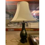 A DECORATIVE ORIENTAL TABLE LAMP ON CARVED WOODEN BASE