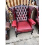 AN OXBLOOD WINGED CHAIR ON CABRIOLE LEGS