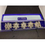 AN ORNATE FLOWER DESIGN WHITE METAL BRACELET (POSSIBLY SILVER) IN A PRESENTATION BOX