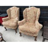 A PAIR OF GEORGIAN STYLE WINGED EASY CHAIRS ON CABRIOLE LEGS WITH CARVED KNEE