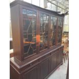 A REGENCY STYLE ASTRAGAL GLAZED FOUR DOOR BOOKCASE ON BASE, ENCLOSING FOUR FRIEZE DRAWERS AND FOUR