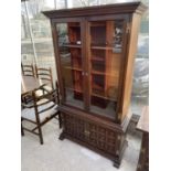 A YOUNGER TOLEDO GLAZED TWO DOOR CABINET WITH TWO RAISED PANEL DOORS TO THE BASE AND H-BRASS HINGES,