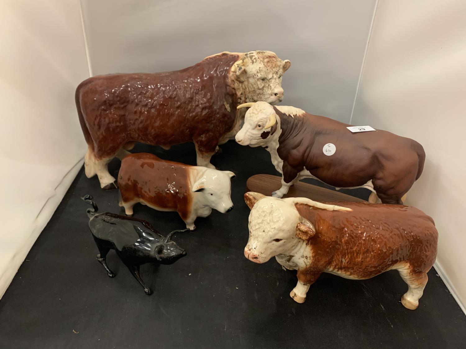 FOUR HEREFORD BULL ORNAMENTS TO INCLUDE A FURTHER SMALL BLACK BULL