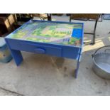 A CHILDS TABLE WITH ROAD TRACK DECORATION AND STORAGE DRAWER