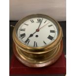 A LARGE BRASS SHIP'S CLOCK WITH KEY - 20CM DIAMETER