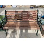 A WOODEN SLATTED GARDEN BENCH WITH CAST IRON BENCH ENDS