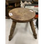 A VINTAGE WOODEN FOUR LEGGED MILKING STOOL