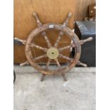 A VINTAGE WOODEN SHIPS WHEEL WITH BRASS CENTRE