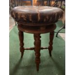 A VINTAGE ROUND LEATHER BUTTONED PIANO STOOL