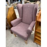 A MODERN WINGED FIRESIDE CHAIR ON CABRIOLE FRONT LEGS